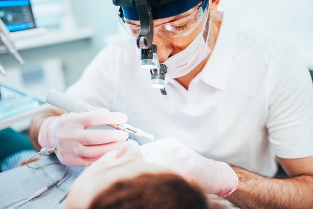 An endodontist prepares to perform a root canal on a patient.