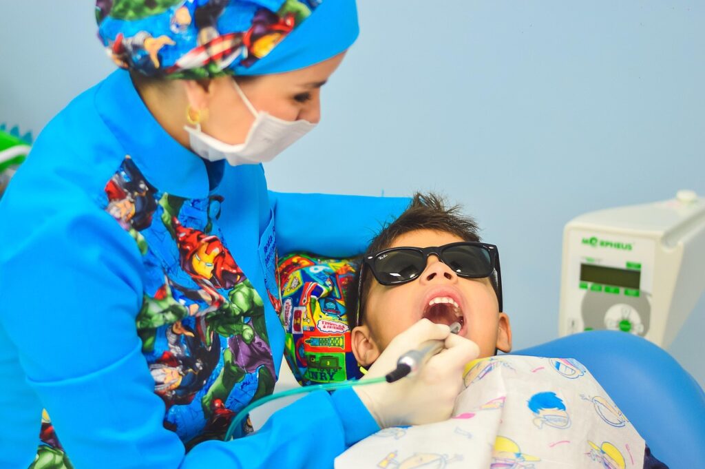 child wearing sunglasses and getting teeth cleaned